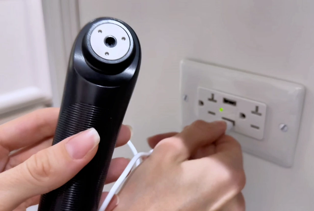 Real STOGA IRH-1 shown with its USB charging cable in a home setting