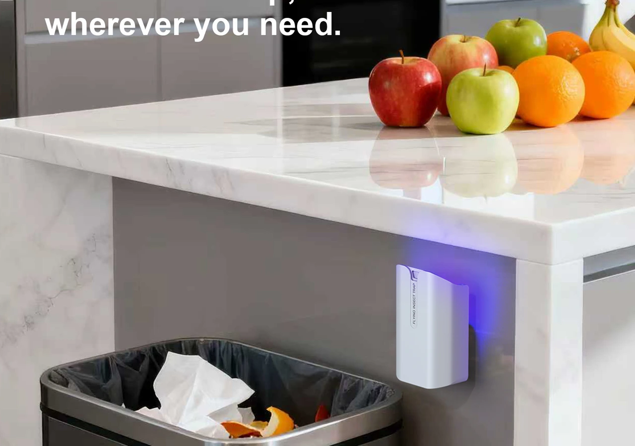 Cordless rechargeable STOGA M81 small-fly trap placed by a kitchen waste area away from food-contact surfaces